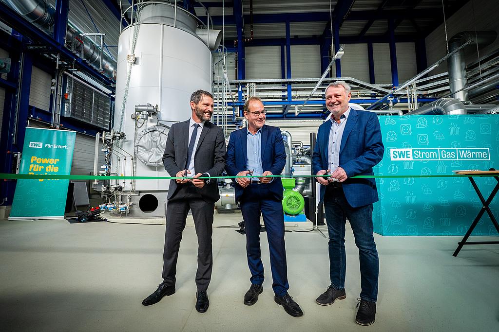Minister schneidet ein Band durch.