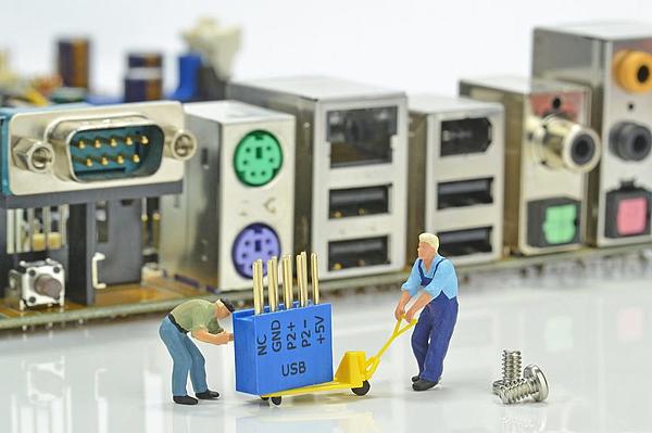 Modellfiguren reparieren einen Computer